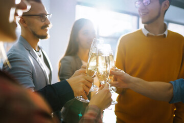 Clinking glasses with champagne. Happy coworkers celebrating their business achievement on a party in the office. Partners celebrating their victory. 
