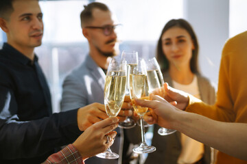 Clinking glasses with champagne. Happy coworkers celebrating their business achievement on a party in the office. Partners celebrating their victory. 