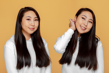 Pretty smiling young asian girl with healthy perfect long hair satisfied with hairs after haircare treatment procedure