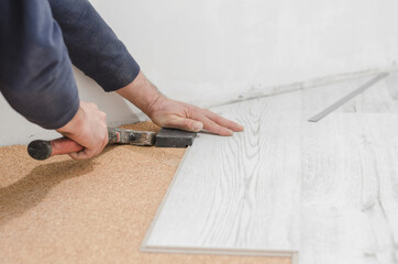 Unrecognizable man laying laminate flooring. Professional laying of flooring - laminate