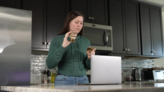 Smiling woman takes remote lesson to learn finger cymbals online on a laptop. Remote learning concept.