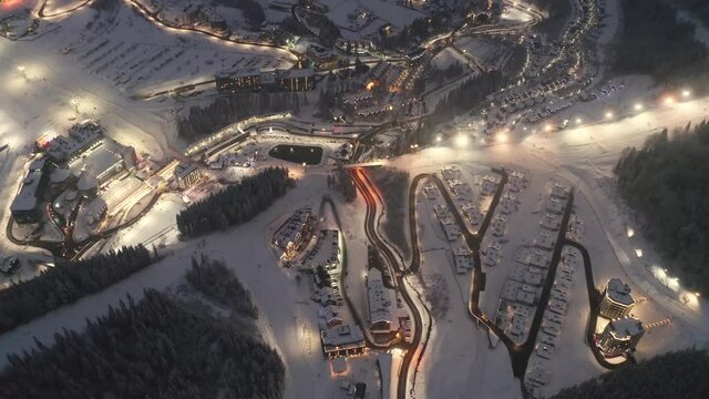 ski resort in the Carpathians was filmed from the air at Christmas night, before the New Year. Colorful cottages and houses filled with road cars - people driving home
