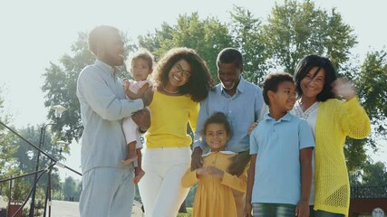 Beautiful happy african american family bonding at the park. Parents, grandparents and kids spending time outdoor playing and having fun - Powered by Adobe