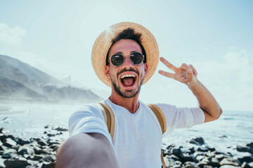 Happy handsome man taking selfie outside - Smiling guy having fun on the beach - Mobile, travel and...