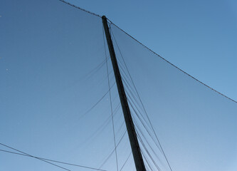 post and protective netting on a blue sky in winter
