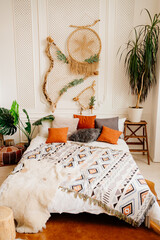 bedroom decor in eco style. bed with a dreamcatch on the wall. 