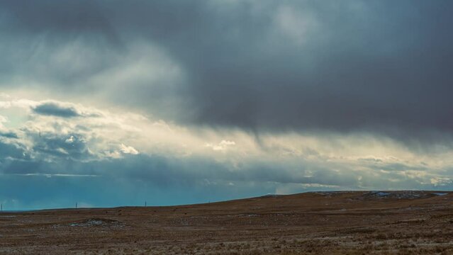 time lapse of rolling clouds in a winter storm over the rural Wyoming prairie with cows