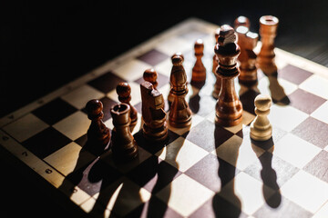 One pawn staying against full set of black chess pieces. One against all. Hero