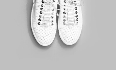 Sneakers isolated on blue background, fashion. White shoes. Pair of white shoes on blue background. Overhead shot of running shoes. Close up, modern fashion shoes made of laces