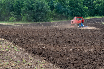 Fototapeta premium Tractor work on the spring field. Farmer's spring work.