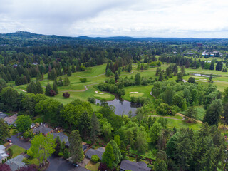 Shooting from a drone. Small city. A lot of greenery - trees, bushes, lawns. Mountain range. Blue...