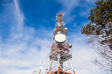 Telecommunication tower. Communication and connection. Wireless antene. Blue sky with clouds in...