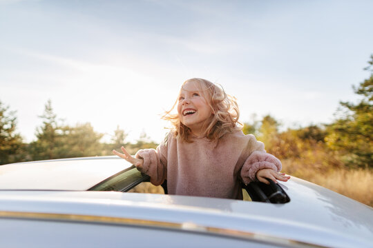 Cute girl in sunroof of car