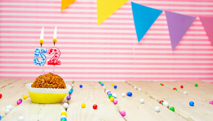 Happy birthday for 52 years old. Festive background with muffin. Copy space birthday card for fifty...