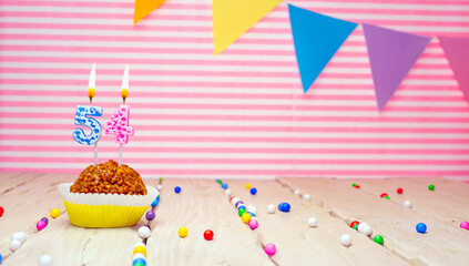 Happy birthday for 54 years old. Festive background with muffin. Copy space birthday card for fifty...