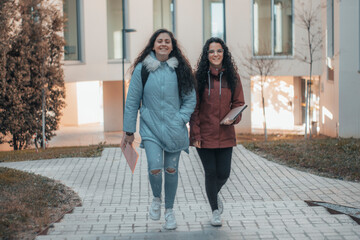 Jovenes adolescentes estudiantes de la facultad de medicina paseando por el recinto escolar para entregar unas tareas en clase con una sonrisa de felicidad