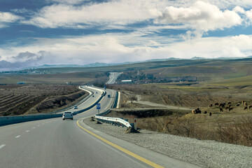 Curving asphalt road between Baku and Shamakhi districts and hills in background, Azerbaijan