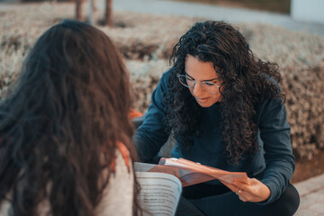 Muchacha joven alumna sonriente estudiando para el examen en el descanso de su centro universitario...