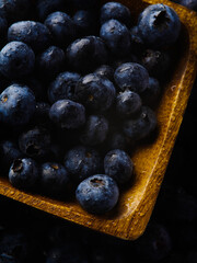 macro photography. Fresh blueberries in a yellow bowl. Useful product, vitamins, diet food. Medicine, cooking. Restaurant, cafe, hotel, advertising, banner.