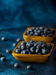 Blueberries in bowls on a dark blue background. Cooking, medicine, healthy food, diet, fitness. Restaurant, hotel, cafe, home cooking, food blog. macro photography.