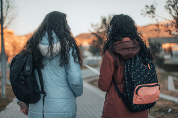 Estudiantes del campus universitario hablando y caminando por las instalaciones de la universidad con la mochila	