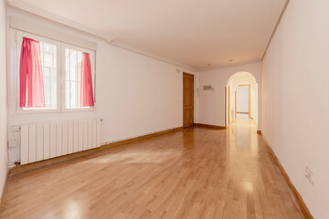 Living room with white aluminum radiators, window with pink curtains and corridor with decorative round arches