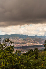 Fototapeta na wymiar Paisaje con árboles, montañas y nubes en la isla de Tenerife