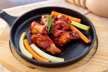 chicken wings in barbecue sauce on black iron pan