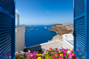 View from a terrace room with shutters and flowers of the Aegean Sea and caldera in the village of Oia on the island of Santorini, Greece.	 - obrazy, fototapety, plakaty