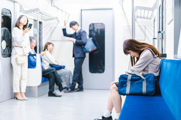 Fototapeta na wymiar 電車内で腹痛に苦しむ女子高生