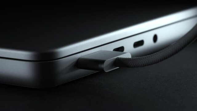 MagSafe 3 power adapter connecting to new laptop. Charger for laptop close-up. Metal silver version