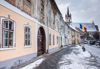  Evangelical Church Tower  in Bistrita , january 2022,and the flag of Romania ,view from Nicolae  Titulescu street