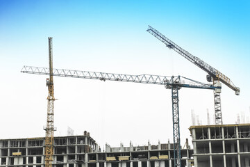 Tower crane, development of urban structures and construction of houses industry architecture on blue sky background
