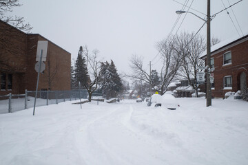 Toronto, Ontario / Canada - January 17, 2022 - Toronto St Clair West sideroad with cars covered on day of snowstorm