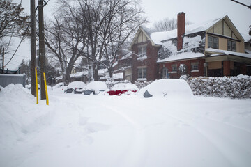 Fototapeta na wymiar Toronto, Ontario / Canada - January 17, 2022 - Toronto St Clair West sideroad with cars covered on day of snowstorm