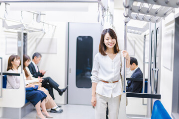 Fototapeta na wymiar 笑顔で電車に乗る若い女性
