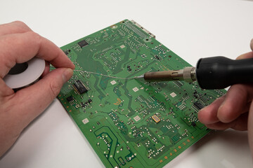 Electronics repair. Technician soldering component on circuit board. First person pov.