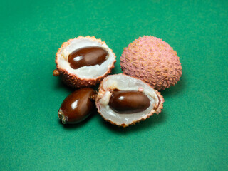 Sliced ​​lychee. Round pimply fruits. Chinese plum. Fruit peel. Peeling the lychee. Pieces of juicy fruit on a bright background.