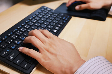 キーボードをタイピングする左手