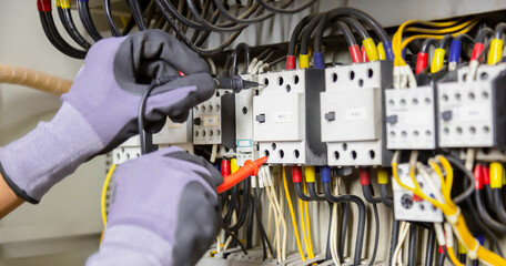 Electrician engineer tests electrical installations and wires on relay protection system....
