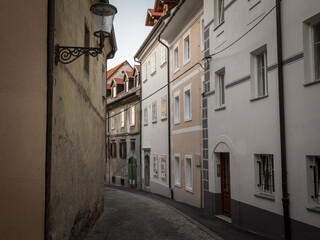 Studentovska ulica Street, an empty picturesque cobblestone medieval and narrow street by the Ljubljanski Hrad, Ljubljana castle in Slovenia with European medieval houses and trees. ..