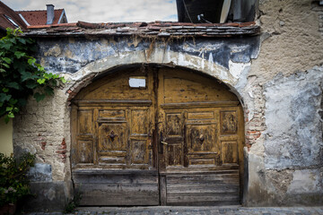 Old entrance door, wooden gate, decayed, medieval style, made of ancient wood, still being used in front of a historical building in downtown zagreb, Croatia...