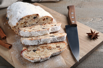 Traditional Christmas Stollen with icing sugar on wooden table
