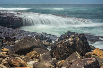 ocean wave cascade over rock shelf - long exposure