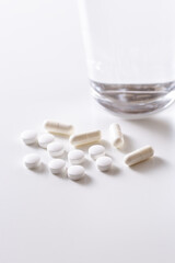 Fototapeta na wymiar 白背景に白い錠剤とカプセル薬