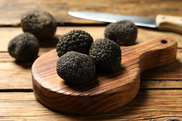 Fototapeta na wymiar Black truffles with board on wooden table