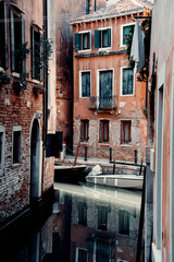 Narrow canal surrounded by old buildings in Venice, Italy