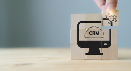 AI-CRM solution concept. Data driven marketing strategy with AI. For marketing plan, providing automated interaction to customer. Hand hold wooden cubes with AI-CRM icon on grey background, copy space