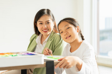 beautiful young children happy, smile, look at camera, fun painting color in education classroom, select focus at child. asian beautiful children happy and fun color painting education in small school