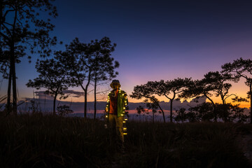 Woman standing with the pine forest during sunset on Phu Kradueng park, Thailand